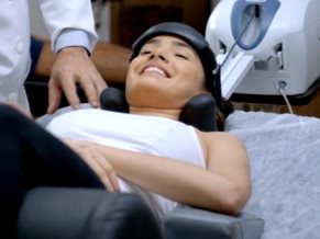 Paciente deitada e sorrindo com a cabeça apoiada no aparelho de tração cervical